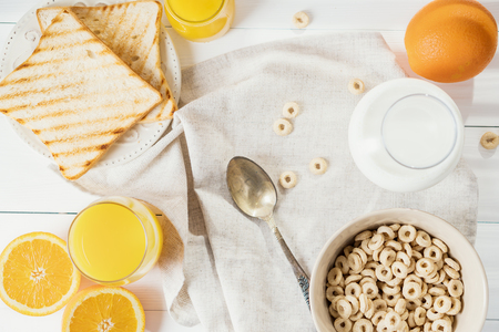 Whole Grain Cereal rings, milk, honey and orange juice on the white table.の写真素材