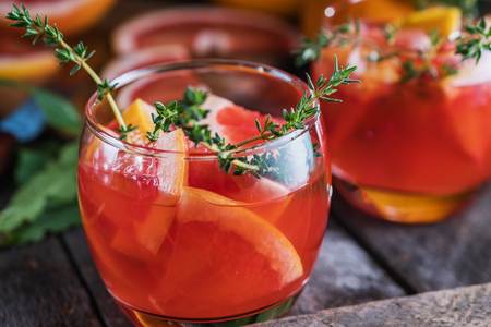 Grapefruit and thyme cocktail. Refreshing drink on rustic background.の写真素材