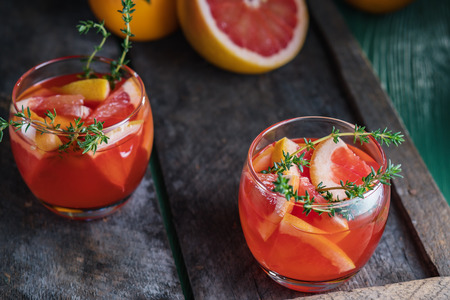 Grapefruit and thyme cocktail. Refreshing drink on rustic background.の写真素材