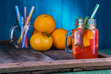Cocktail with grapefruit and rosemary, long drink. Pink cocktail in mason jar bottle on old dark rustic background.の写真素材