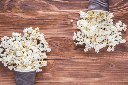 Popcorn in brown paper cups on rustic wooden background with copy space, top view, flat lay.の写真素材