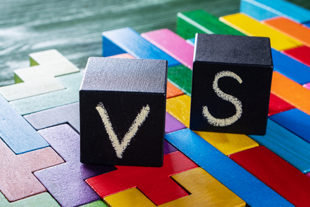 Letters VS on colorful wooden background with copy space. The concept of making choice. Versus concept. Black cubes with letters VS.の写真素材
