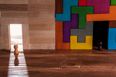Abstract man in the doorway. Colorful wall of wooden puzzles.  Success concept. Pathway of opportunity. Target, achievement, business metaphor.の写真素材