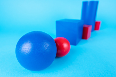 Blue and red geometric shapes on blue background. Abstract construction from wooden blocks. The concept of creative, logical thinking. Different wooden shapes.の写真素材
