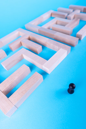 People in the maze, finding a way out. The man in the maze. The concept of a business strategy, analytics, search for solutions, the search output. Labyrinth of wooden blocks.の写真素材
