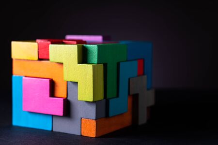 Cube made of multicolored wooden geometric shapes. Concept of decision making process, creative, logical thinking. Choose correct answer. Logical tasks. Conundrum.の写真素材