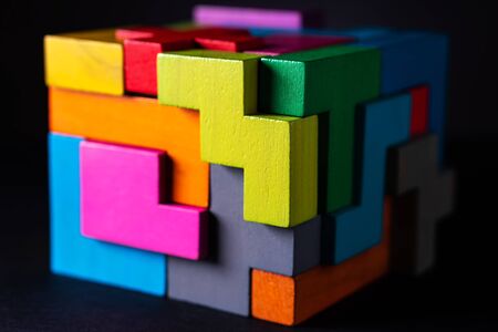 Cube made of multicolored wooden geometric shapes. Concept of decision making process, creative, logical thinking. Choose correct answer. Logical tasks. Conundrum.の写真素材