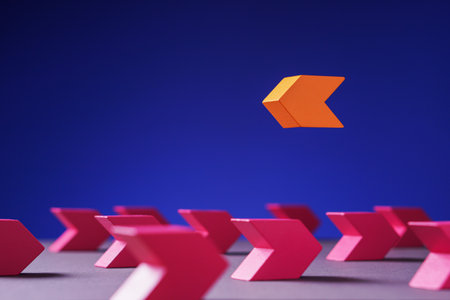 Pink arrow facing the opposite direction from orange arrows. Concept of individuality,...