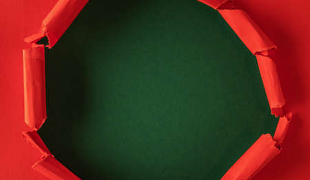 Red paper is torn over green background for message. Template for your text.の写真素材