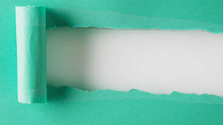 Turquoise paper is torn over white background for message. Template for your text.の写真素材