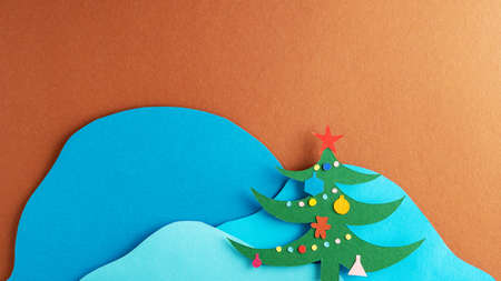 Christmas tree with decorations on the background of snowy mountains. Paper art.の写真素材
