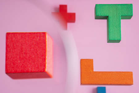 Geometric shapes on a pink background. Different colorful shapes wooden blocks on pink background, 3D. Concept of creative, logical thinking.の写真素材