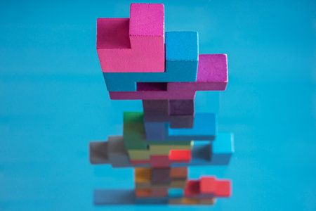 Abstract construction from wooden blocks on blue backgroundの写真素材