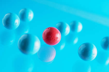 Blue and red balls flowing upwards on blue background. Abstract background with bright balls. One against all, concept photo. Concept of business success.の写真素材