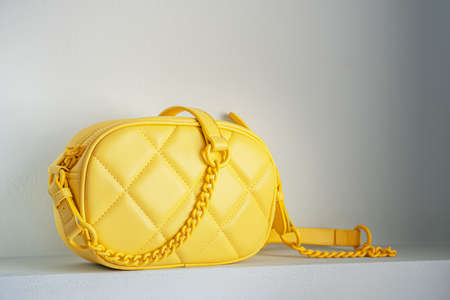 Yellow cross body quilted bag. Ladies bright-colored handbag on gray background. yellow woman bag.の写真素材