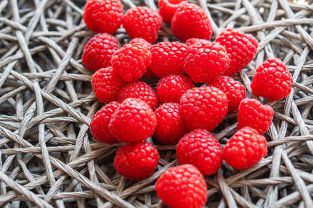 Fresh organic raspberry on a wicker napkin with copy space. rustic backgroundの写真素材