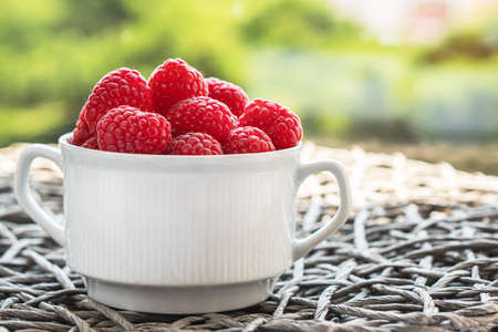 Fresh raspberries in the white bowl on the gray background.の写真素材