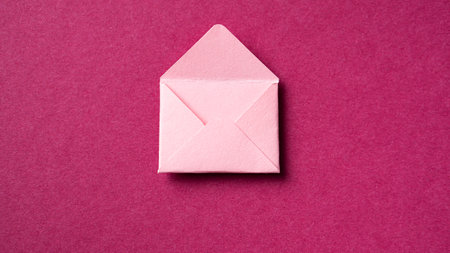 Blank open pink envelope on a dark pink background. Background for women's holidays and Valentine's dayの写真素材