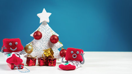 Snowmen made of Red Christmas socks around a Christmas tree with gifts. Xmas and New Year concept. xmas backgroundの写真素材