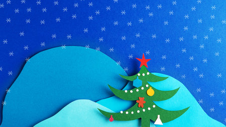 Christmas card with decorated Christmas tree and snowflakes on the background of mountainsの写真素材