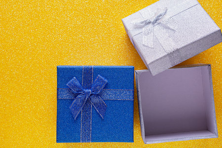 Yellow background with two glitter gift box with copy space. gift concept, flat lay. top view. Blue...