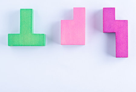 Concept of creative, logical thinking. Different colorful shapes wooden blocks on white background, flat lay, copy space. Geometric shapes in different colors, top view. Abstract Background.の写真素材