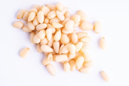 Pine nuts pile and separate kernels on white background.の写真素材