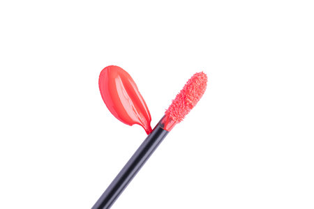 Red liquid lipstick and applicator isolated on white background. Swatch of red lip gloss. Top view, flat lay, copy spaceの写真素材