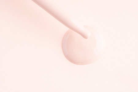 Drops of liquid make-up foundation texture with pipette on the nude color backgroundの写真素材