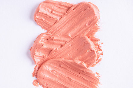 Orange clay mask smear smudge isolated on white background. Cream texture. Facial mask, skincare beauty product swatch closeup. SPA background.の写真素材