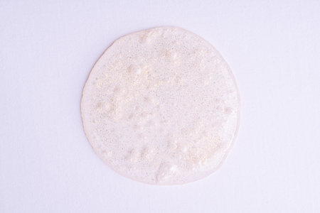 Banner shimmer golden cosmetic sample texture isolated on white background. Cosmetic glittering shower gel. Cosmetic shiny face serum, lotion, moisturizer, beauty backgroundの写真素材
