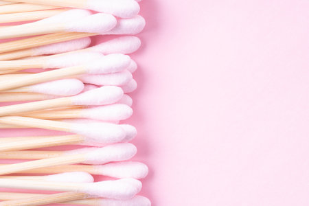 Heap of light pink cotton buds on pink background, top view with copy spaceの写真素材