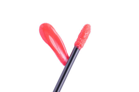 Red liquid lipstick and applicator isolated on white background. Swatch of red lip gloss. Top view, flat lay, copy spaceの写真素材