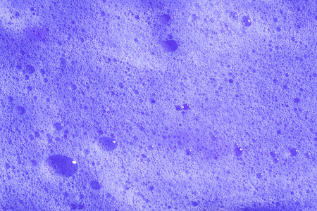 Purple hair shampoo foam. Violet lavender foaming soap closeup. Foam texture background. Macroの写真素材