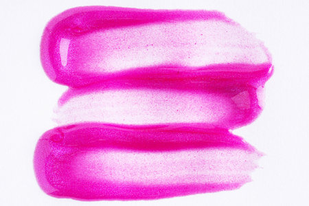 Purple shimmer swatch of lip gloss, cosmetic product stroke or paint, macro. Swatches of violet lipgloss or paint on white paper background.の写真素材