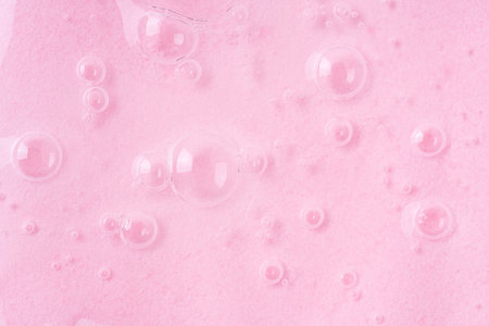 Molecule bubbles in a cosmetic serum, macro. Transparent cosmetic aloe gel with molecule bubbles on pink.の写真素材