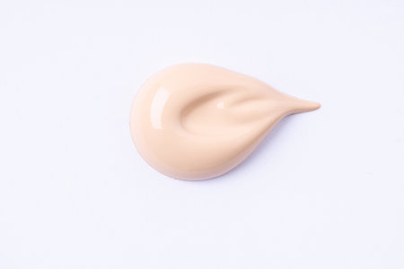 A smear of foundation cream or concealer on white background, macro. Texture of cosmetic liquid foundation or beige cream smudge, smear, stroke.の写真素材