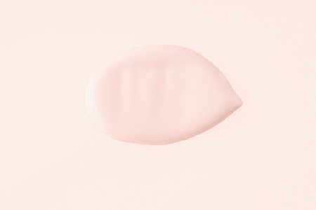 Swatch of liquid make-up foundation texture on the nude color background. Cosmetics samplesの写真素材
