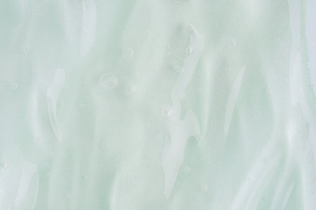 Light green transparent cosmetic gel for skin, aloe vera gel sample with bubbles. Hand sanitizer, alcohol gel blob. Cosmetic background. Transparent cream swirl, close upの写真素材
