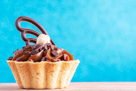 Delicious cupcake on blue glitter background with copy space. Caramel cupcake, close up, copy spaceの写真素材