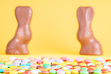 Easter concept. Two chocolate Easter bunny and Chocolate eggs on yellow background, space for text. Top viewの写真素材