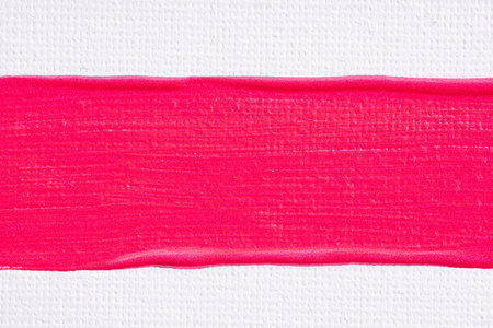 Smear of lipstick, lip gloss, paint, nail polish on a white paper canvas background. Bright pink cosmetic product brush stroke sample. Textured pink oil paint brush stroke.の写真素材
