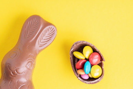 Easter concept. Chocolate Easter bunny and Chocolate eggs on yellow background, space for text. Top viewの写真素材