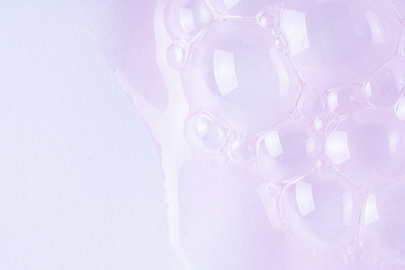 Clear pink cosmetic gel with molecule bubbles on white backgroundの写真素材