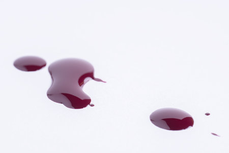 Splattered red paint on white background. Splash of dark redの写真素材