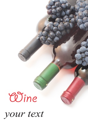 three bottles of wine with grapes isolated on white background の写真素材