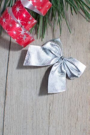 christmas fir tree and red ribbon  on wooden background の写真素材