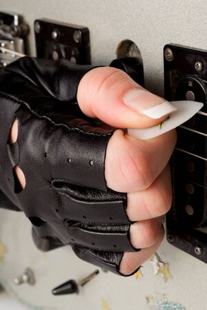 Female hands playing on electrical guitarの写真素材