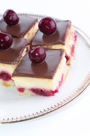 Chocolate cake with cherry on top on a plateの写真素材