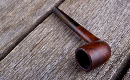 Smoking pipe on wooden table close-upの写真素材